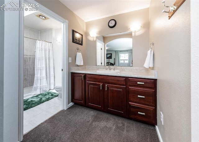 bathroom featuring curtained shower, vanity, toilet, and tile patterned flooring