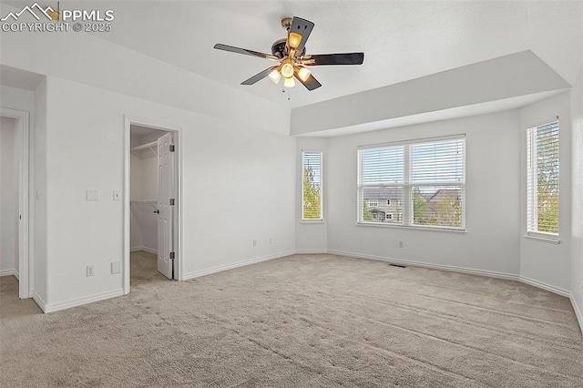 unfurnished bedroom featuring carpet floors, baseboards, a spacious closet, and ceiling fan