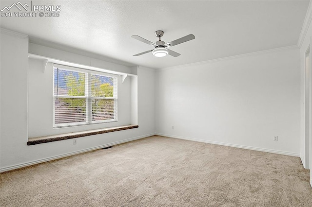 empty room with carpet floors, ceiling fan, baseboards, and crown molding