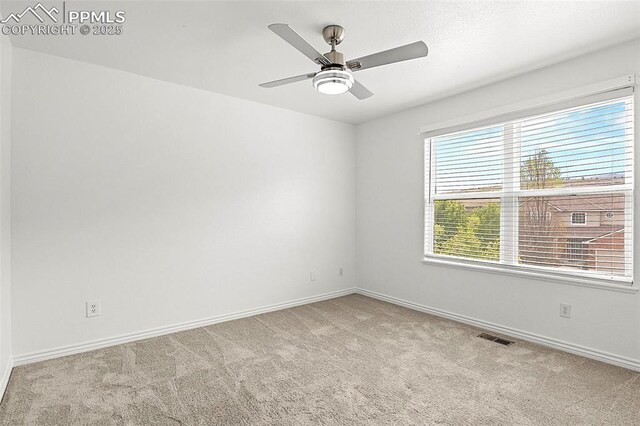 empty room featuring carpet, baseboards, and a ceiling fan