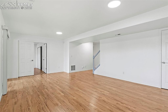 unfurnished living room with stairway, light wood-type flooring, baseboards, and recessed lighting