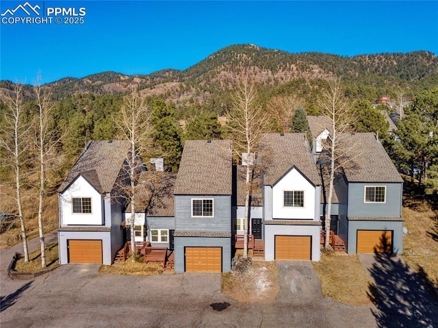 view of front of house featuring a mountain view, an attached garage, and asphalt driveway