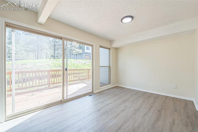 unfurnished sunroom with beamed ceiling