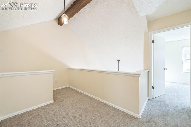 hallway with carpet flooring, baseboards, and an upstairs landing
