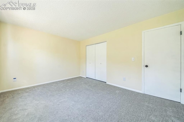 unfurnished bedroom with carpet flooring, baseboards, a closet, and a textured ceiling
