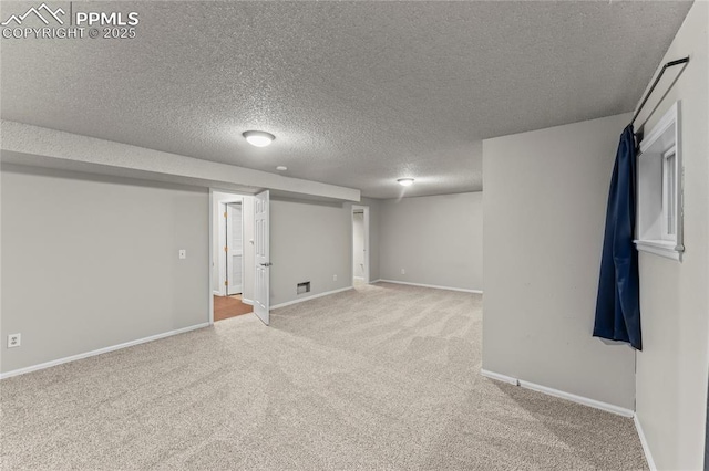 finished basement with carpet floors, a textured ceiling, and baseboards