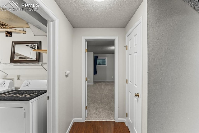 corridor with washing machine and clothes dryer, a textured ceiling, dark wood-type flooring, and baseboards