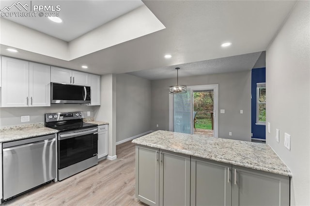 kitchen featuring stainless steel appliances, light wood finished floors, white cabinets, baseboards, and recessed lighting
