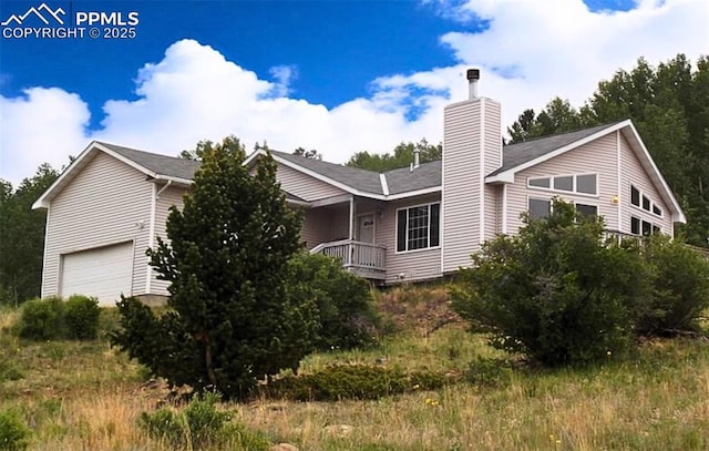 view of side of property featuring a chimney and a garage