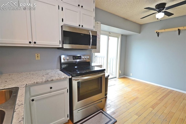 632 Rye Ridge Rd, Fountain, CO 80817 - kitchen with stainless steel appliances, white cabinetry, a ceiling fan, baseboards, and a textured ceiling