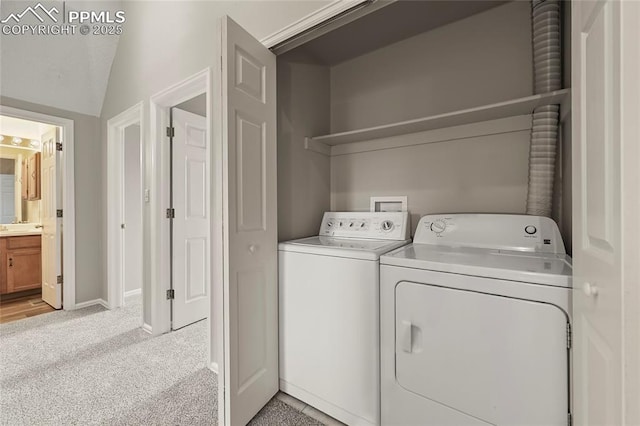 laundry area featuring washer and clothes dryer, light carpet, and baseboards