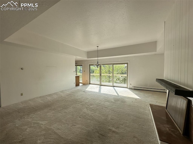 1769 Woodmoor Dr, Monument, CO 80132 - unfurnished living room featuring baseboard heating, carpet, a textured ceiling, and a chandelier