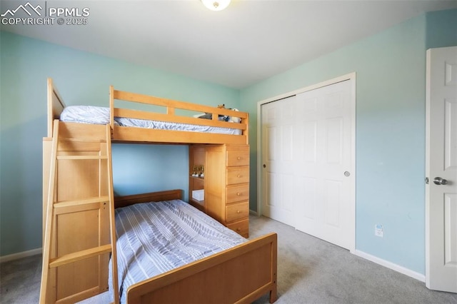 bedroom with carpet flooring, baseboards, and a closet