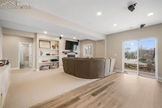 living area with recessed lighting, healthy amount of natural light, wood finished floors, baseboards, and a fireplace