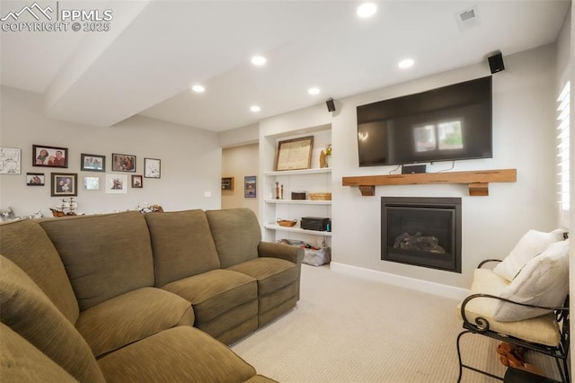 living room with carpet floors, a glass covered fireplace, and recessed lighting