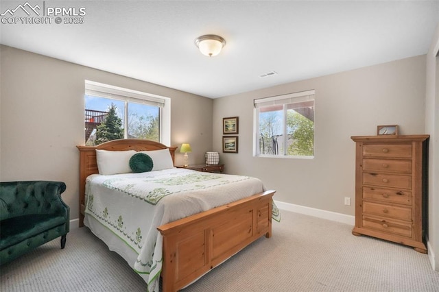 bedroom featuring multiple windows, light colored carpet, and baseboards