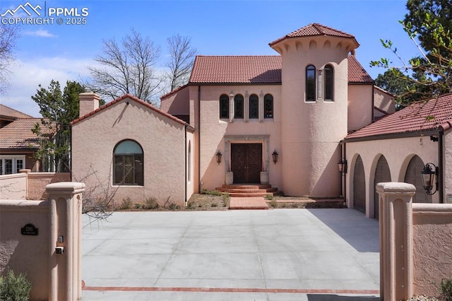 3285 El Pomar Rd, Colorado Springs, CO 80906 - mediterranean / spanish-style house featuring stucco siding, a gate, concrete driveway, a tile roof, and a chimney