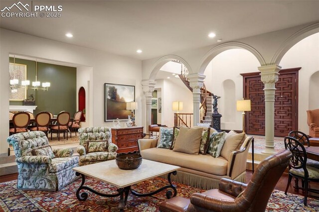 3285 El Pomar Rd, Colorado Springs, CO 80906 - living room with arched walkways, decorative columns, wood finished floors, recessed lighting, and stairs