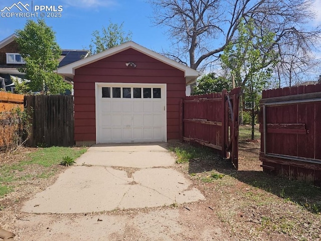 detached garage with fence and driveway