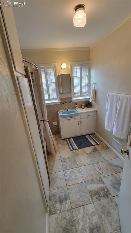 bathroom featuring crown molding, vanity, and curtained shower