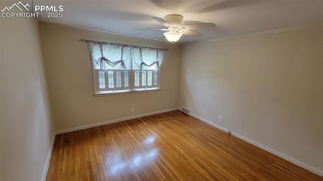 empty room featuring ornamental molding, ceiling fan, baseboards, and wood finished floors