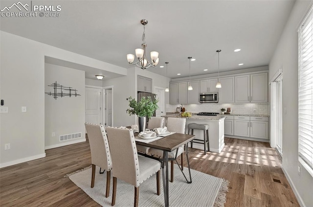 dining area featuring wood finished floors, a chandelier, recessed lighting, and baseboards