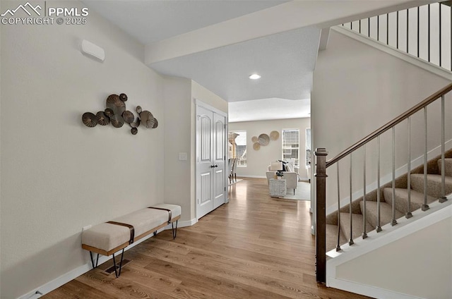 foyer with stairs, wood finished floors, baseboards, and recessed lighting