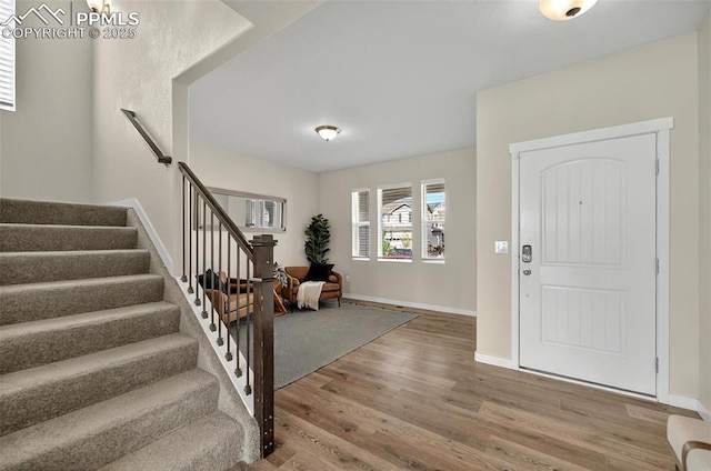 foyer with wood finished floors, stairs, and baseboards