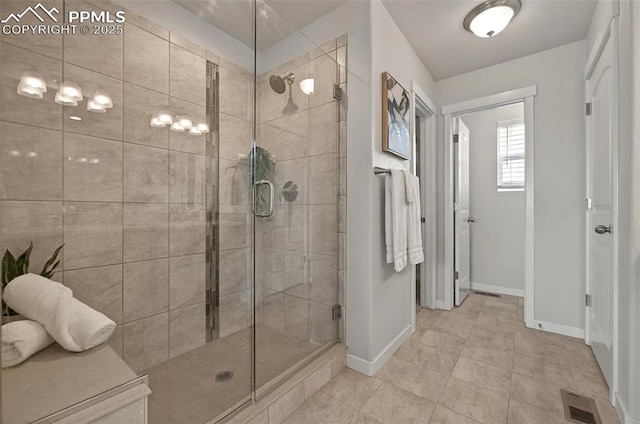 full bath with a shower stall, baseboards, and tile patterned floors