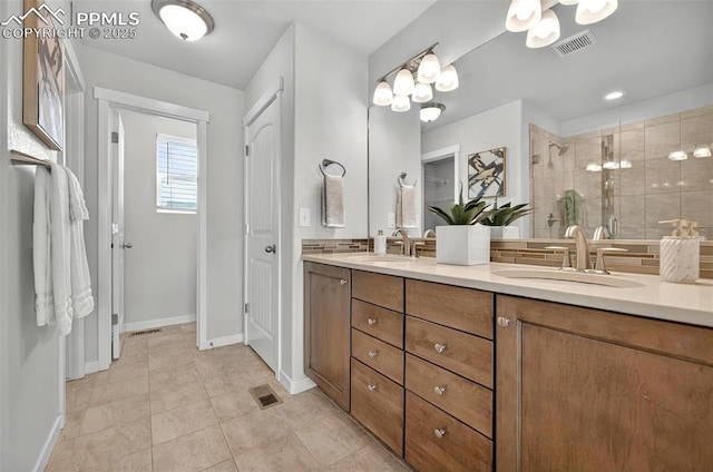 full bath featuring a shower stall, baseboards, tile patterned flooring, and double vanity