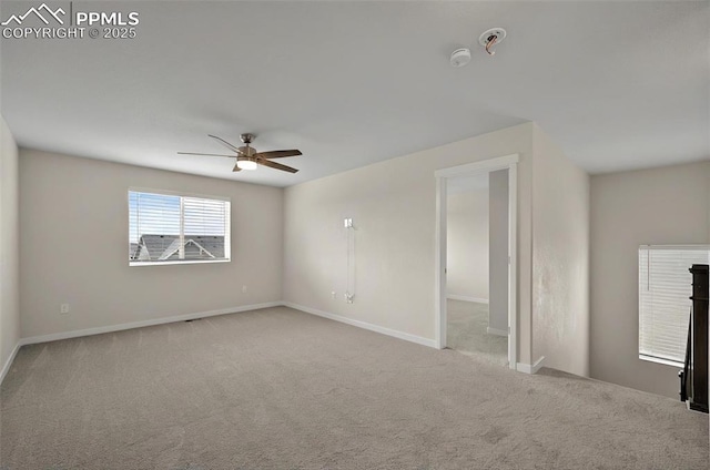 carpeted spare room with ceiling fan, a smoke detector, and baseboards