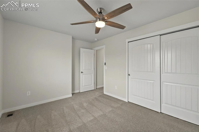 unfurnished bedroom with carpet floors, baseboards, a closet, and a ceiling fan