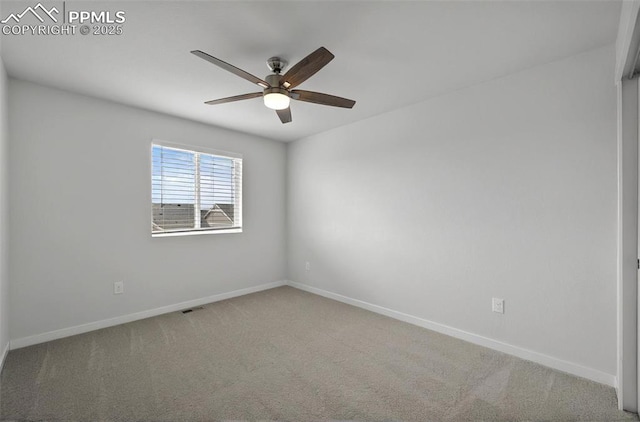 carpeted empty room with a ceiling fan and baseboards