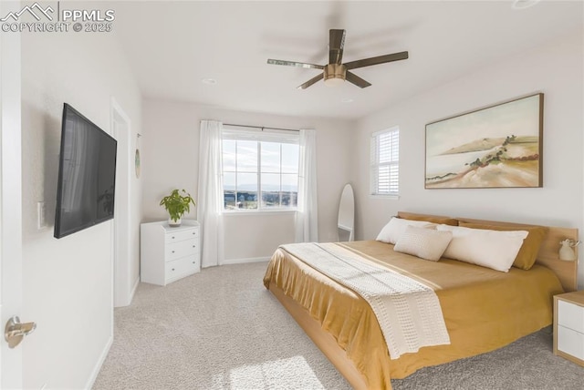 bedroom featuring light carpet, baseboards, and ceiling fan