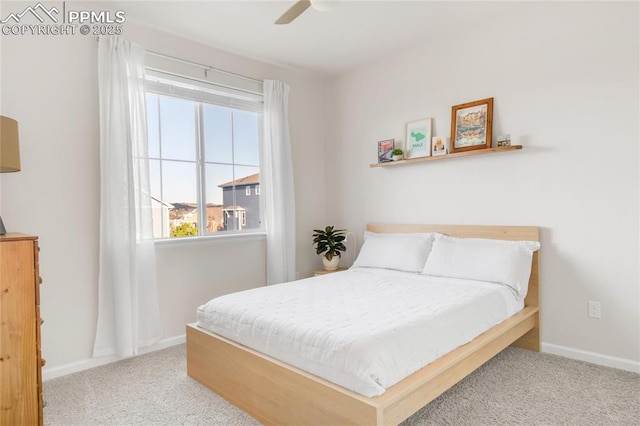 carpeted bedroom featuring baseboards and a ceiling fan