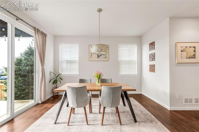 dining room featuring healthy amount of natural light, wood finished floors, and baseboards