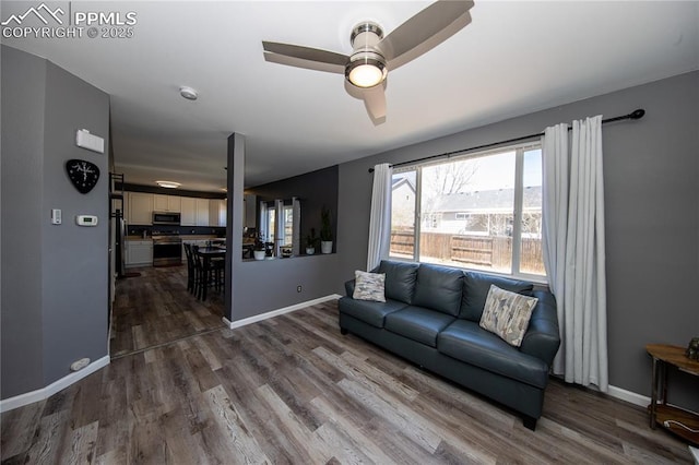 7511 Coffee Rd, Peyton, CO 80831 - living area featuring wood finished floors, a ceiling fan, and baseboards