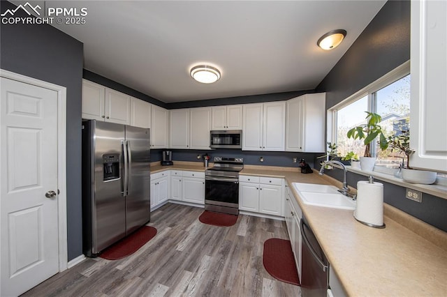 7511 Coffee Rd, Peyton, CO 80831 - kitchen with stainless steel appliances, a sink, light countertops, white cabinetry, and dark wood finished floors