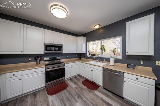 7511 Coffee Rd, Peyton, CO 80831 - kitchen featuring appliances with stainless steel finishes, a sink, white cabinets, and dark wood finished floors