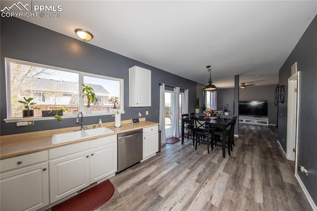 7511 Coffee Rd, Peyton, CO 80831 - kitchen featuring stainless steel dishwasher, a sink, white cabinets, and light wood-style flooring