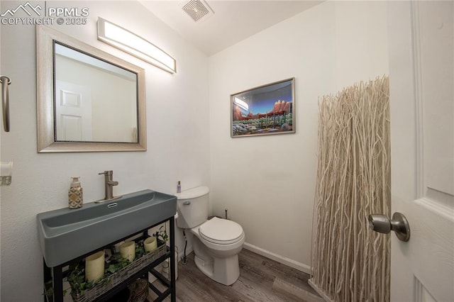 7511 Coffee Rd, Peyton, CO 80831 - half bath with wood finished floors, toilet, baseboards, and vanity