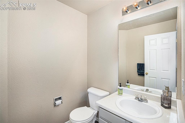 7120 Bonnie Brae Ln, Colorado Springs, CO 80922 - half bath featuring toilet, vanity, and a textured wall