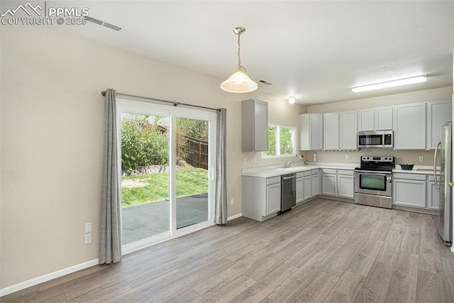 7120 Bonnie Brae Ln, Colorado Springs, CO 80922 - kitchen with stainless steel appliances, light wood-type flooring, a sink, light countertops, and baseboards