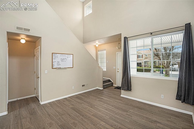 7120 Bonnie Brae Ln, Colorado Springs, CO 80922 - empty room featuring wood finished floors, baseboards, stairway, and a high ceiling