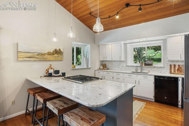 2530 White Rock Ln, Colorado Springs, CO 80904 - kitchen featuring dishwasher, stainless steel gas stovetop, a breakfast bar, wood ceiling, and light wood finished floors