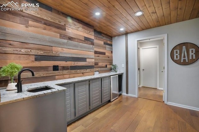2530 White Rock Ln, Colorado Springs, CO 80904 - kitchen with wooden walls, a sink, recessed lighting, light wood finished floors, and gray cabinets