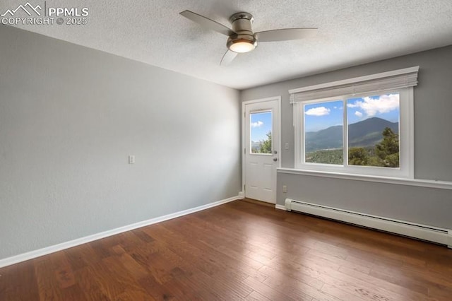 2530 White Rock Ln, Colorado Springs, CO 80904 - empty room featuring a ceiling fan, a baseboard heating unit, wood finished floors, baseboards, and a textured ceiling