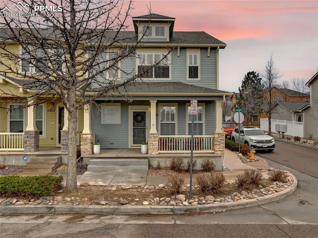 2209 Gilpin Ave, Colorado Springs, CO 80910 - traditional style home with covered porch, stone siding, and roof with shingles