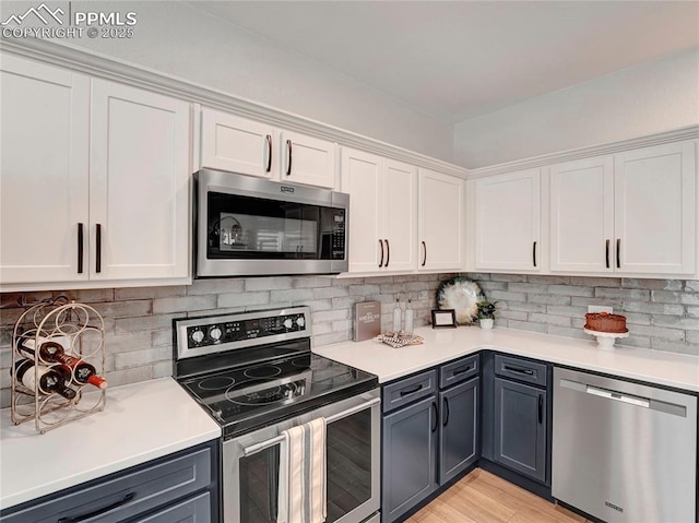2209 Gilpin Ave, Colorado Springs, CO 80910 - kitchen with appliances with stainless steel finishes, white cabinetry, gray cabinets, and tasteful backsplash
