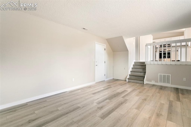 8230 Contrails Dr, Colorado Springs, CO 80920 - bonus room with light wood-style floors, stairs, a textured ceiling, and baseboards